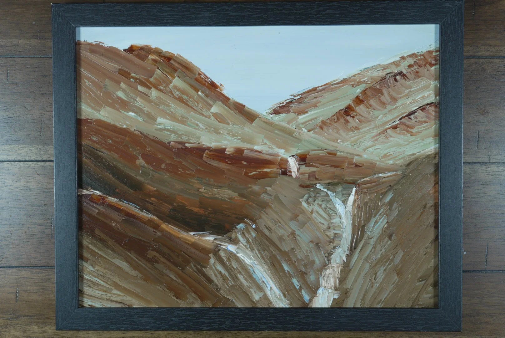 The Ravine in Rust and Stone in a black frame