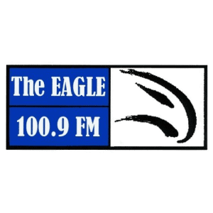 Logo for The Eagle 100.9 FM radio station with a blue background and a stylized eagle in black and white.