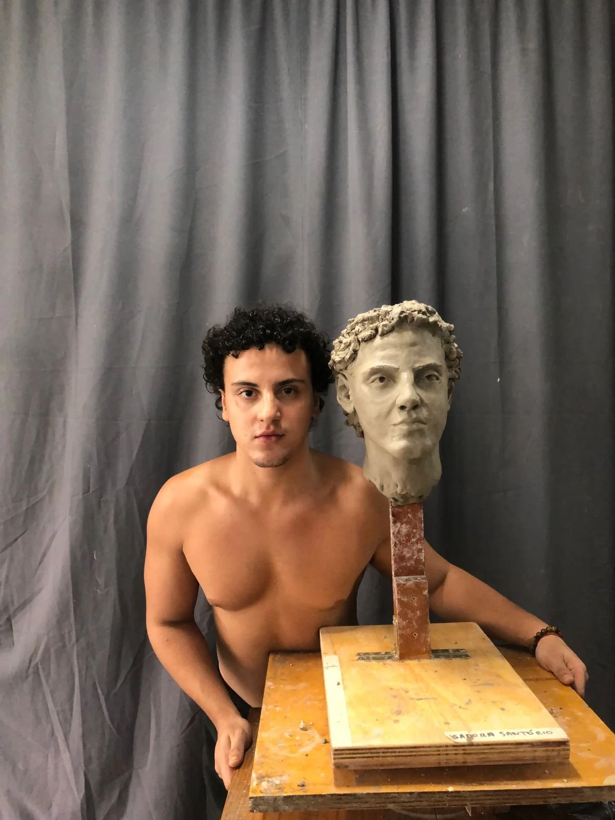 Actor Guilherme posing with the portrait (front view), clay, 2024.