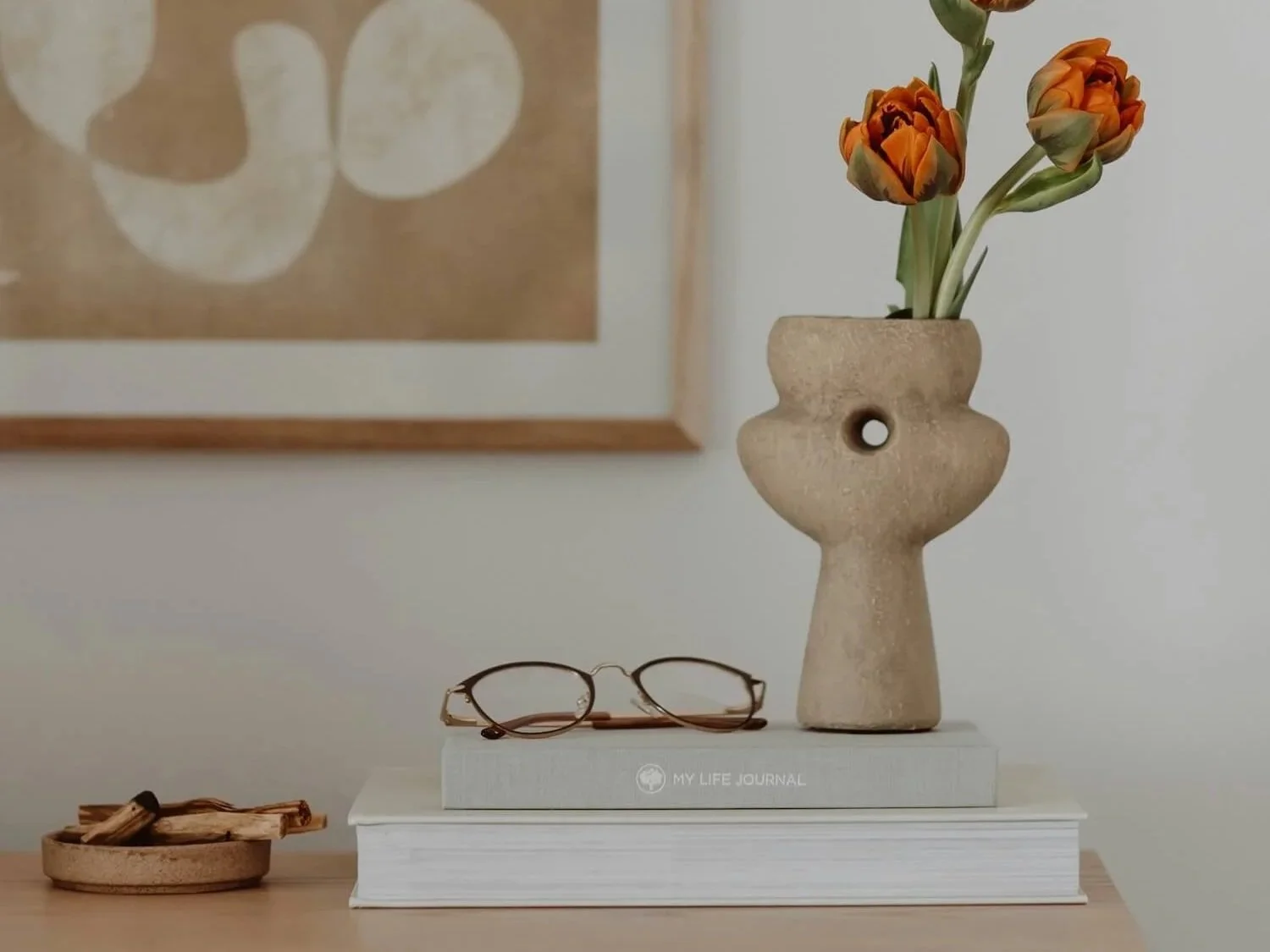 Softly styled flat lay with flowers and objects in warm tones, representing the thoughtful, practical approach of the Love Deliberately course