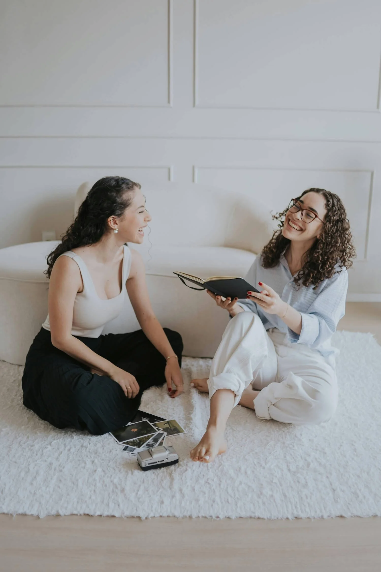 Two women sitting together in relaxed conversation, reflecting the community and connection at the heart of the Love Deliberately course