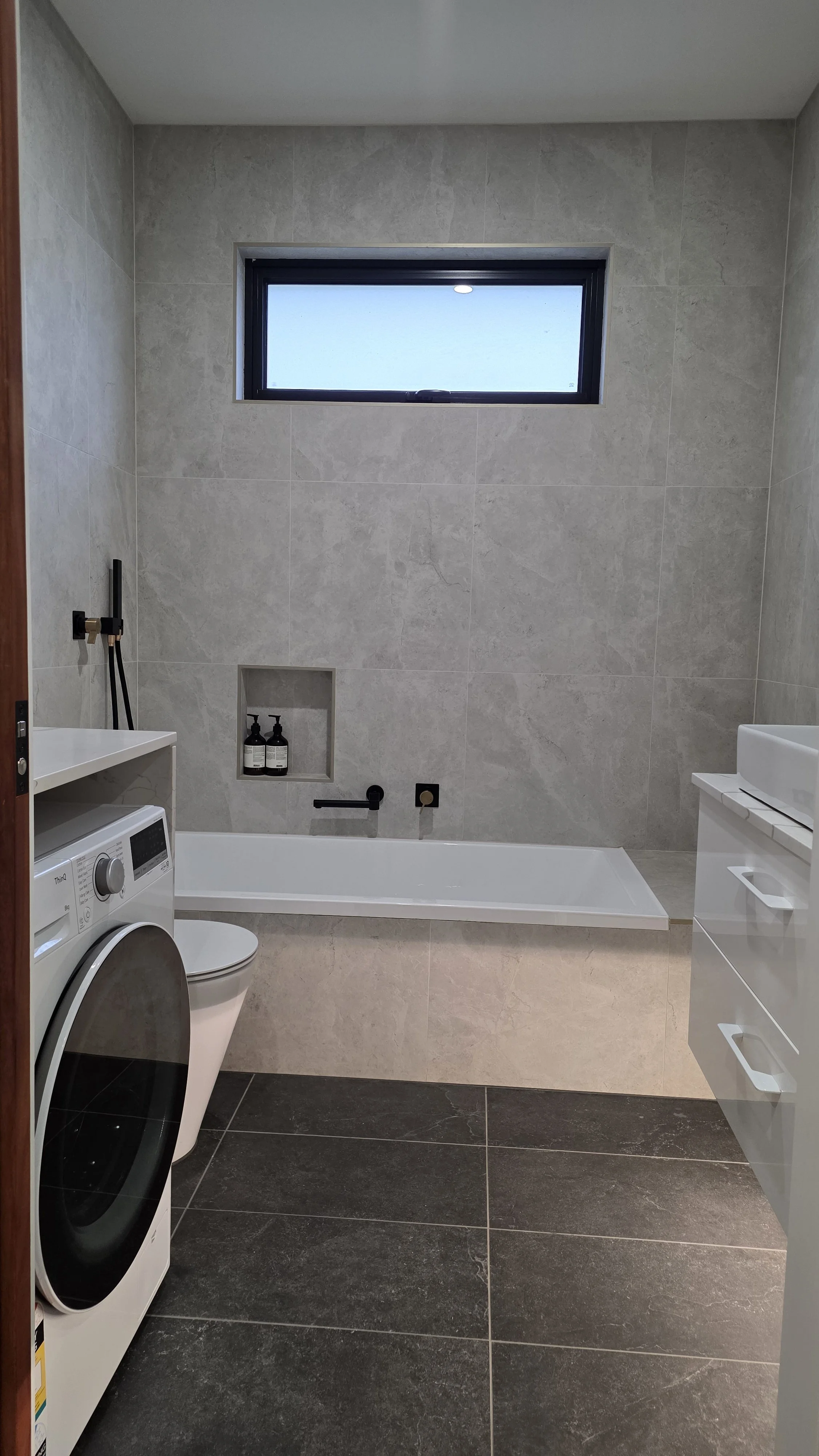 The main bathroom includes a bath, sink, toilet, and washing machine for added comfort and convenience during your stay.