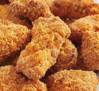 Close-up of several pieces of fried chicken drumsticks with crispy golden coating.