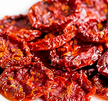A close-up of sun-dried tomatoes on a white plate.