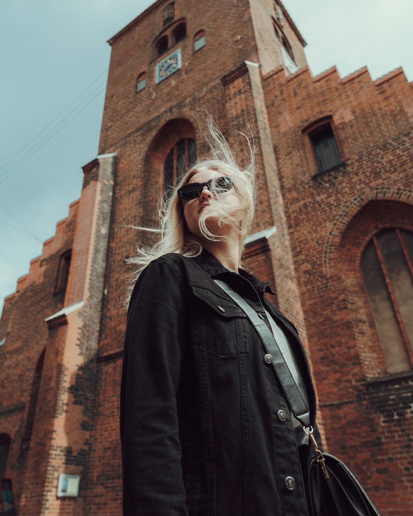 travel-fashion-portrait-woman-black-coat-old-brick-church.jpg