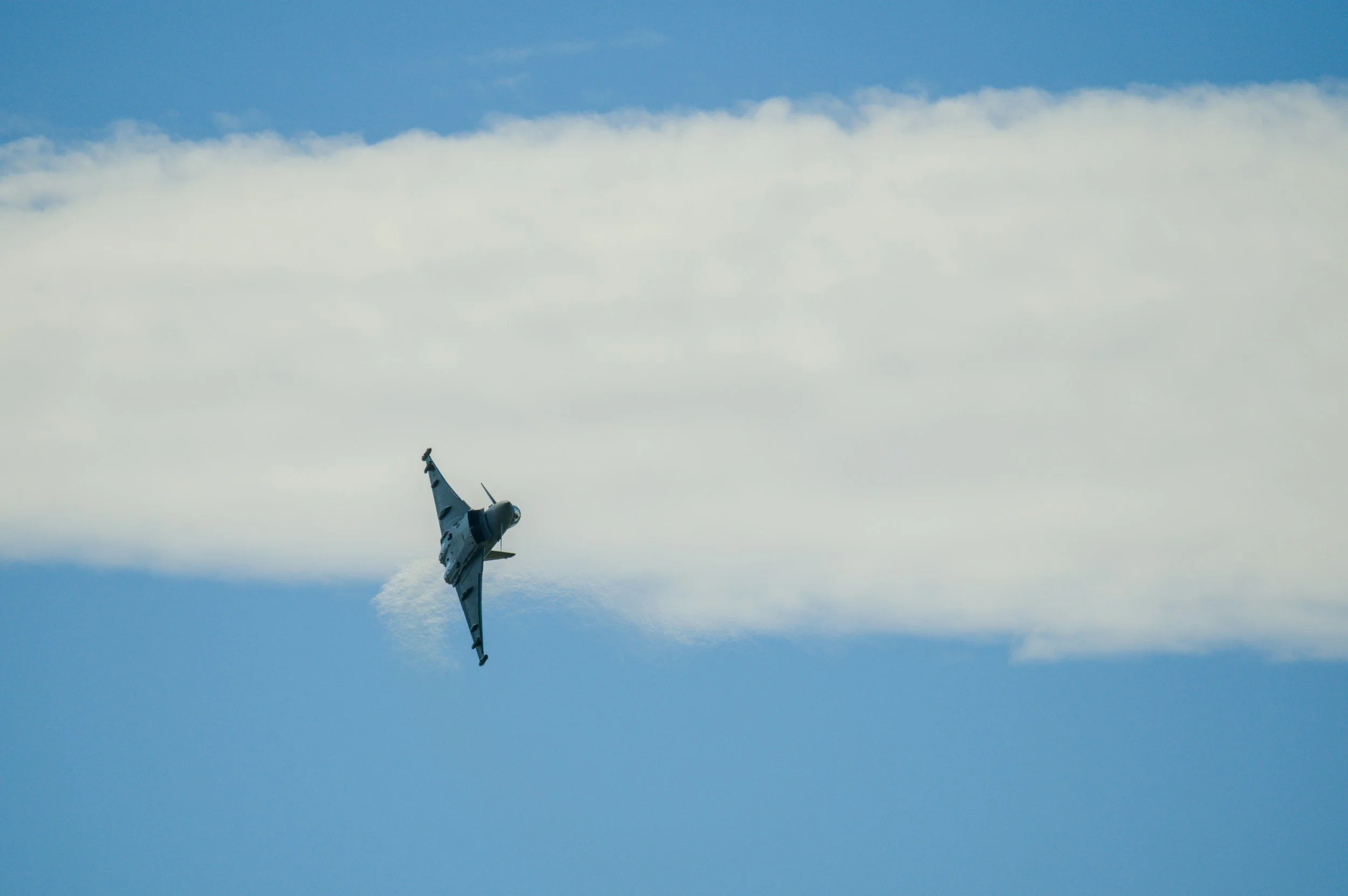 Typhoon military jet performs hard turn on blue sky background