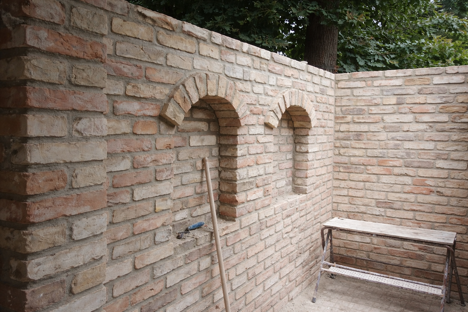 Fertige Ziegelmauer mit Rundbögen im Garten – hochwertige Maurerarbeiten in Brandenburg