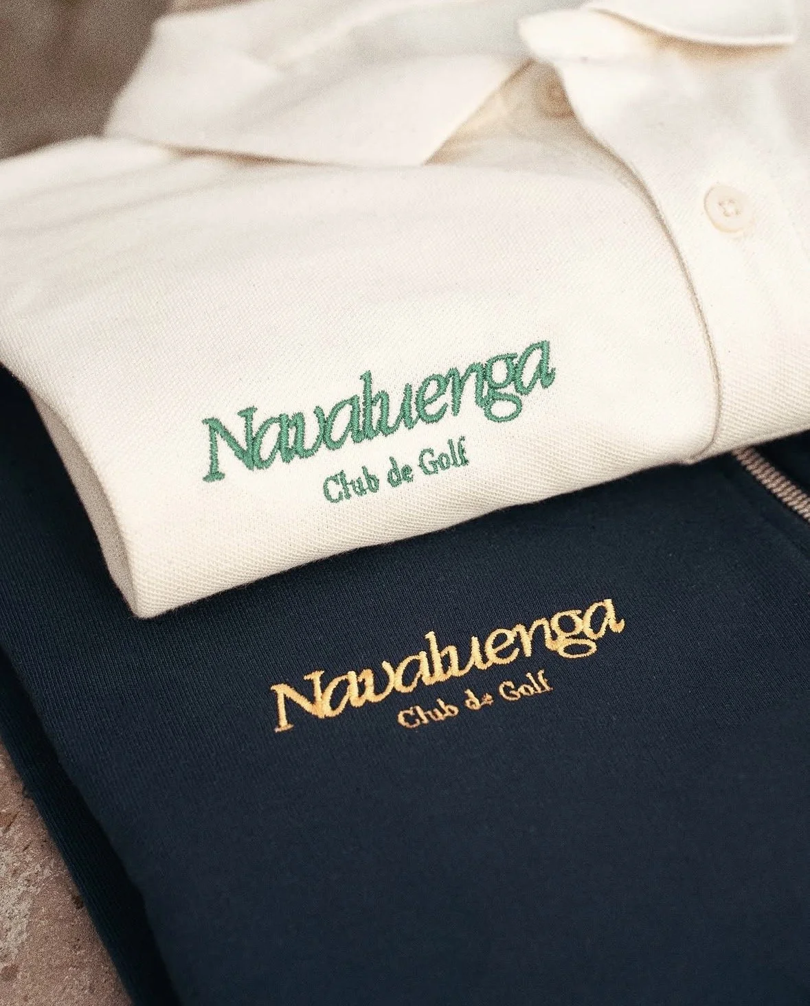 Camisetas blancas y negras con el logo de 'Nautahenga Club de Golf' en diferentes colores.