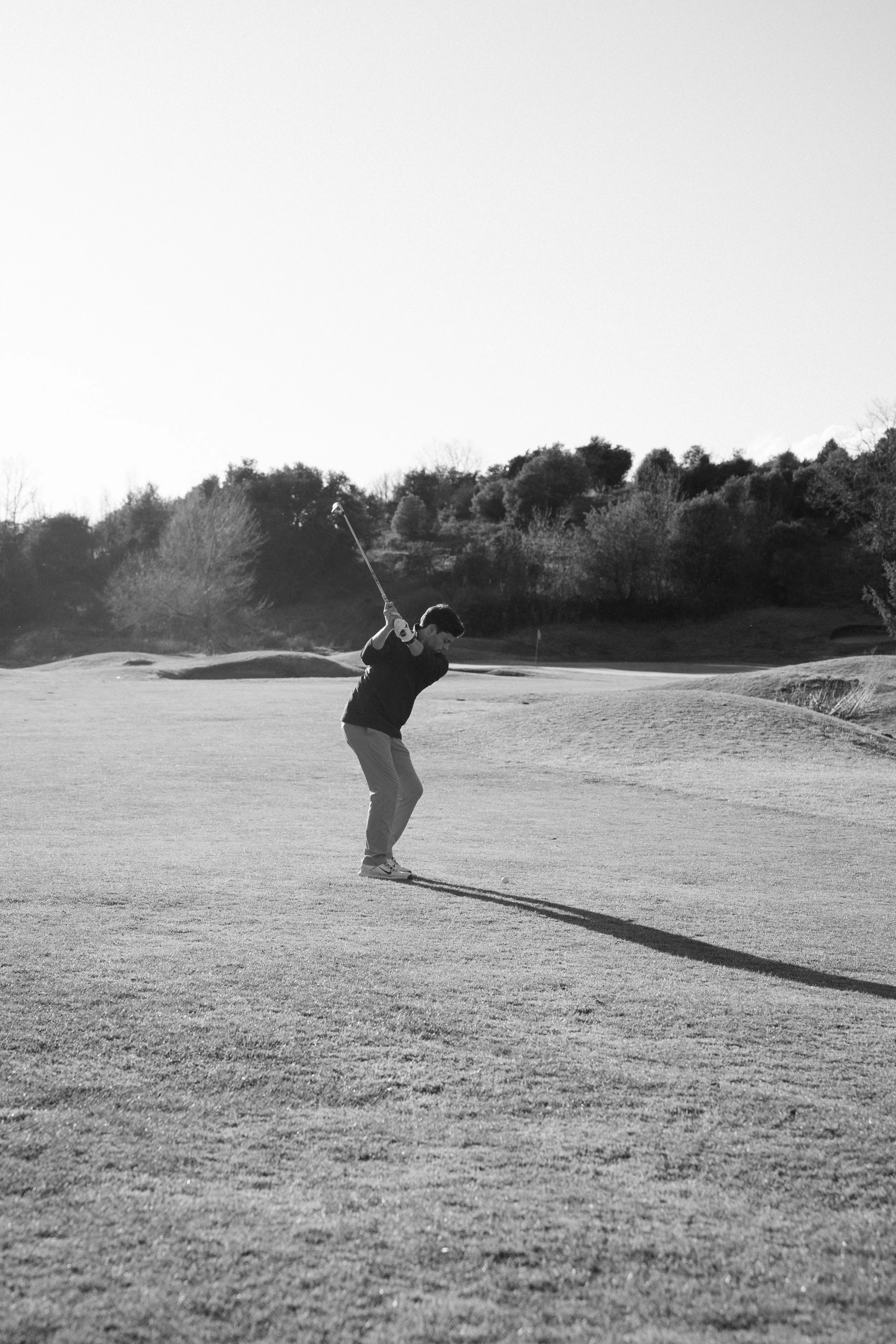 Joven jugando golf en un campo al aire libre en un día soleado