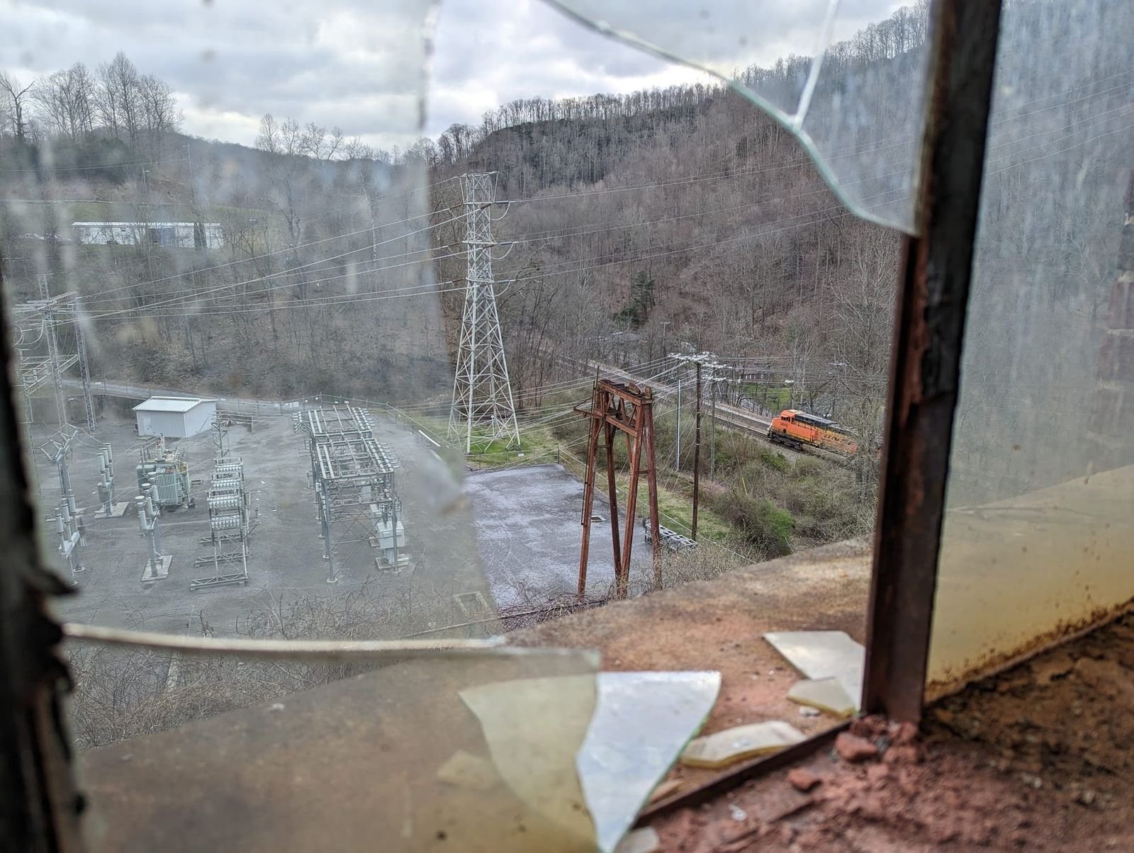 The view of a freight train passing an abandoned power plant deep in Appalachia.