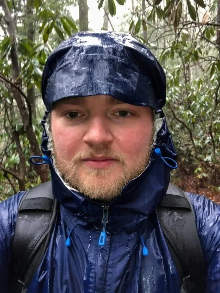 A selfie of Adam Thompson hiking in the rain in the Red River Gorge, Kentucky.