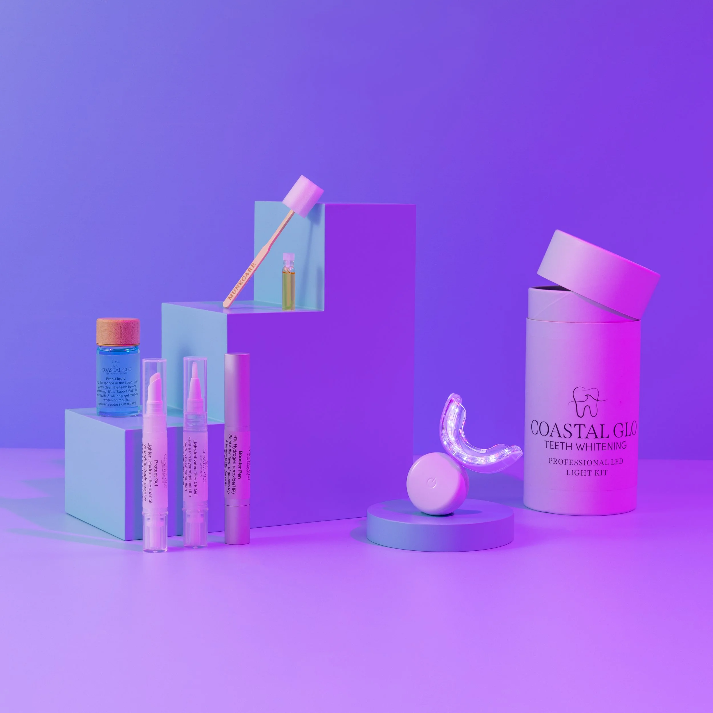 Teeth whitening products, including a toothbrush, toothpaste, various gels, and a teeth whitening kit arranged on white pedestals against a purple background.