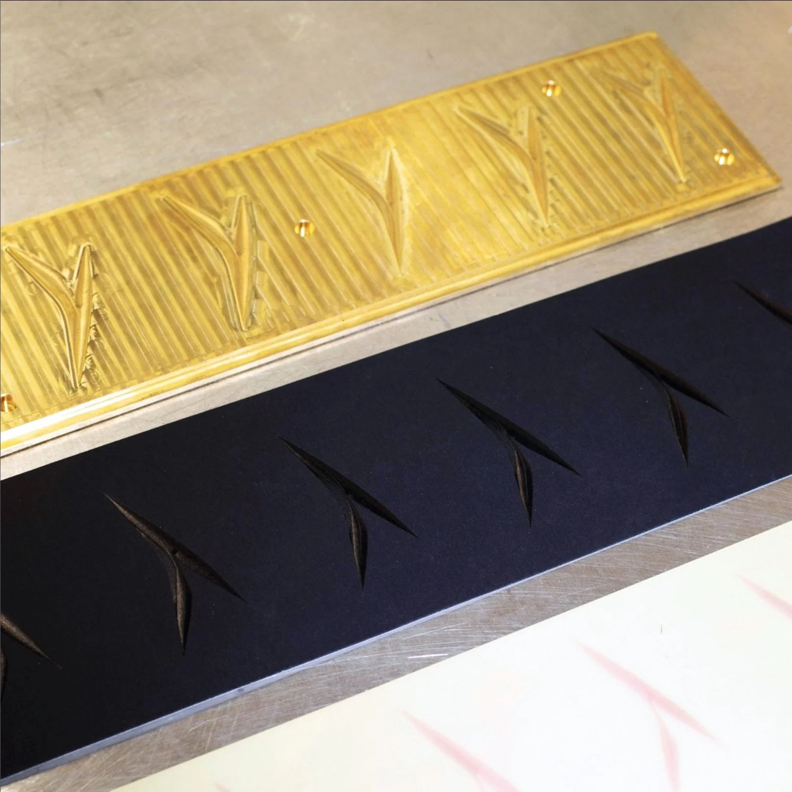 Deux plaques en silicone pour moulage de pâte ou chocolat, une jaune avec un motif de fleurs de lys en relief, l'autre noire avec un motif de diagonales allongées.