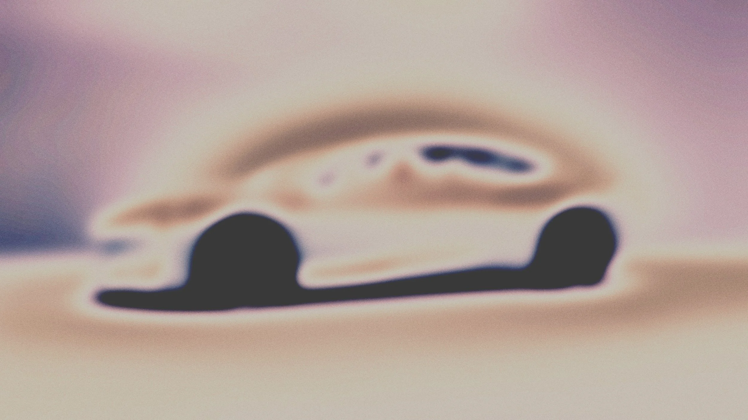 Une image floue et abstraite d'une voiture stylisée vue de côté, avec des couleurs pastel et un effet neuronique ou de distorsion.