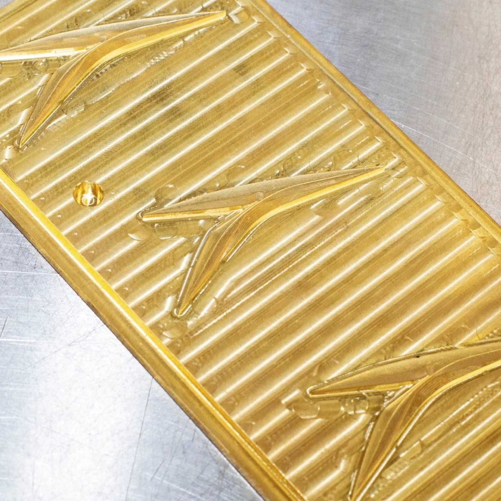 Plaques de verre en forme d'origami dans un moule en plastique jaune.