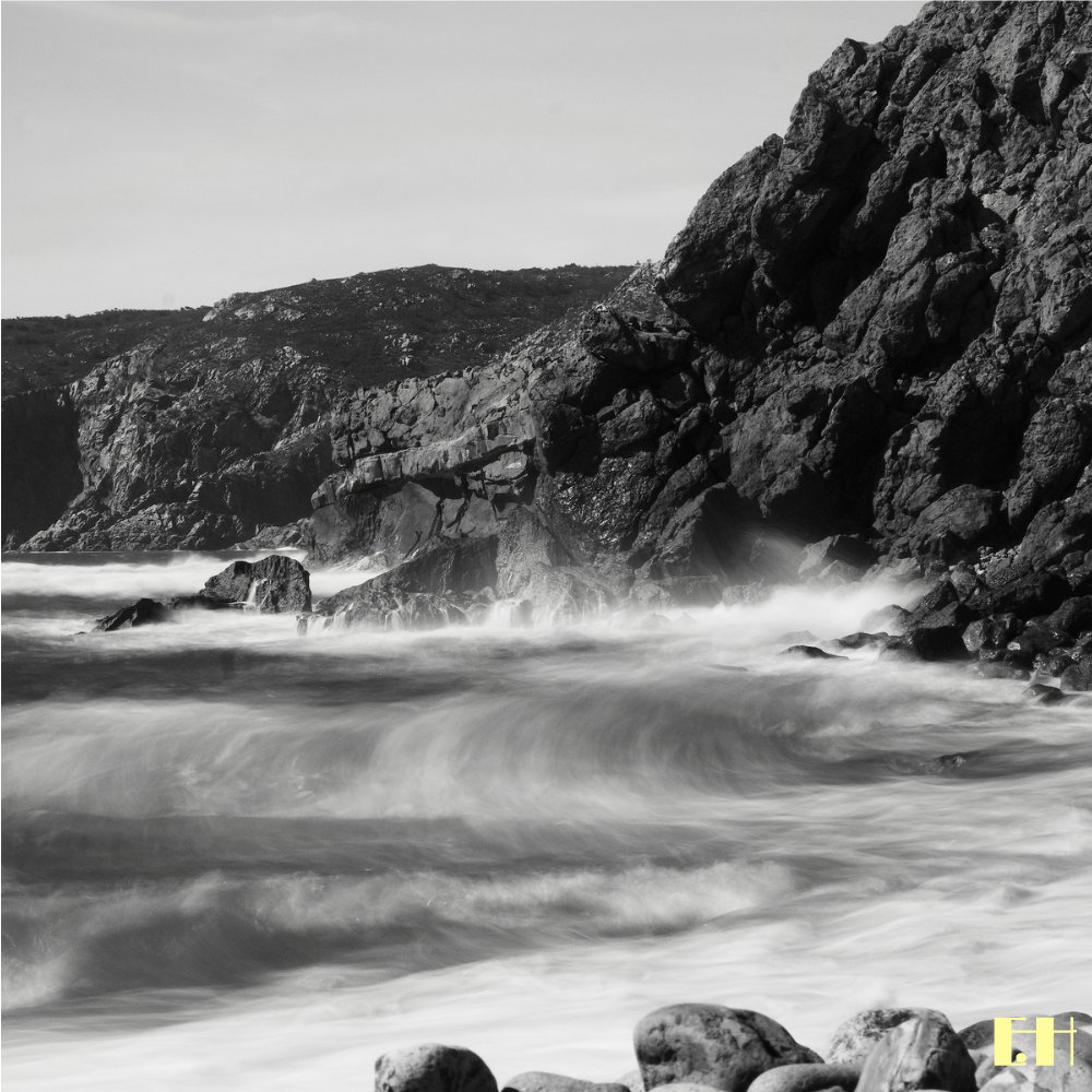Bewegtes Wasser und dunkle Felsen an einer Küste aus der fotografischen Serie Fluctus.