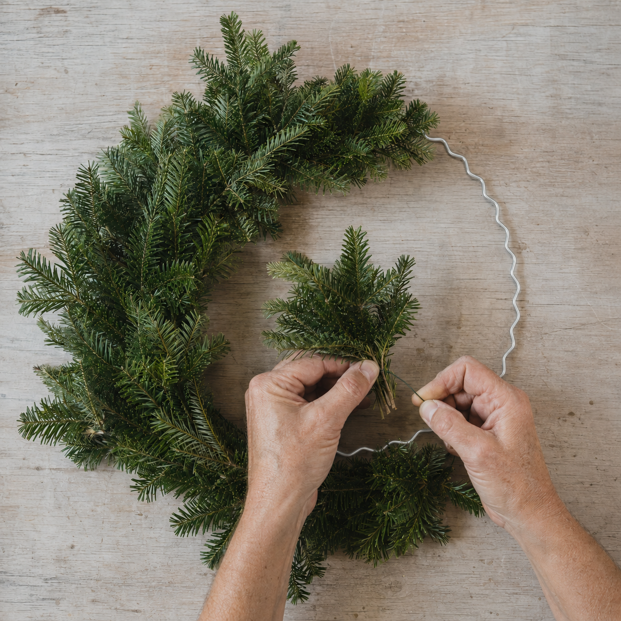 Silver scalloped wire wreath with greenery.png