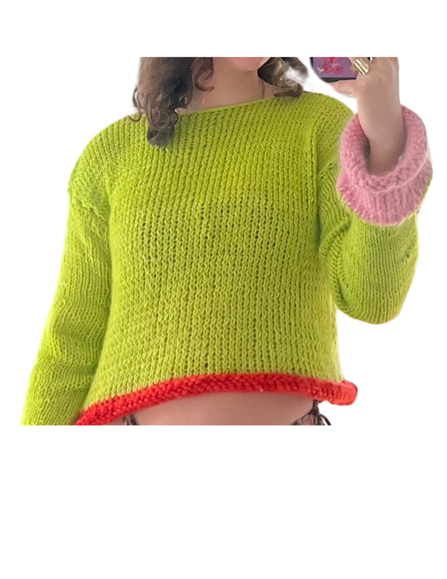A person wearing a bright yellow knitted sweater with pink cuffs and a red trim, taking a mirror selfie with a smartphone.