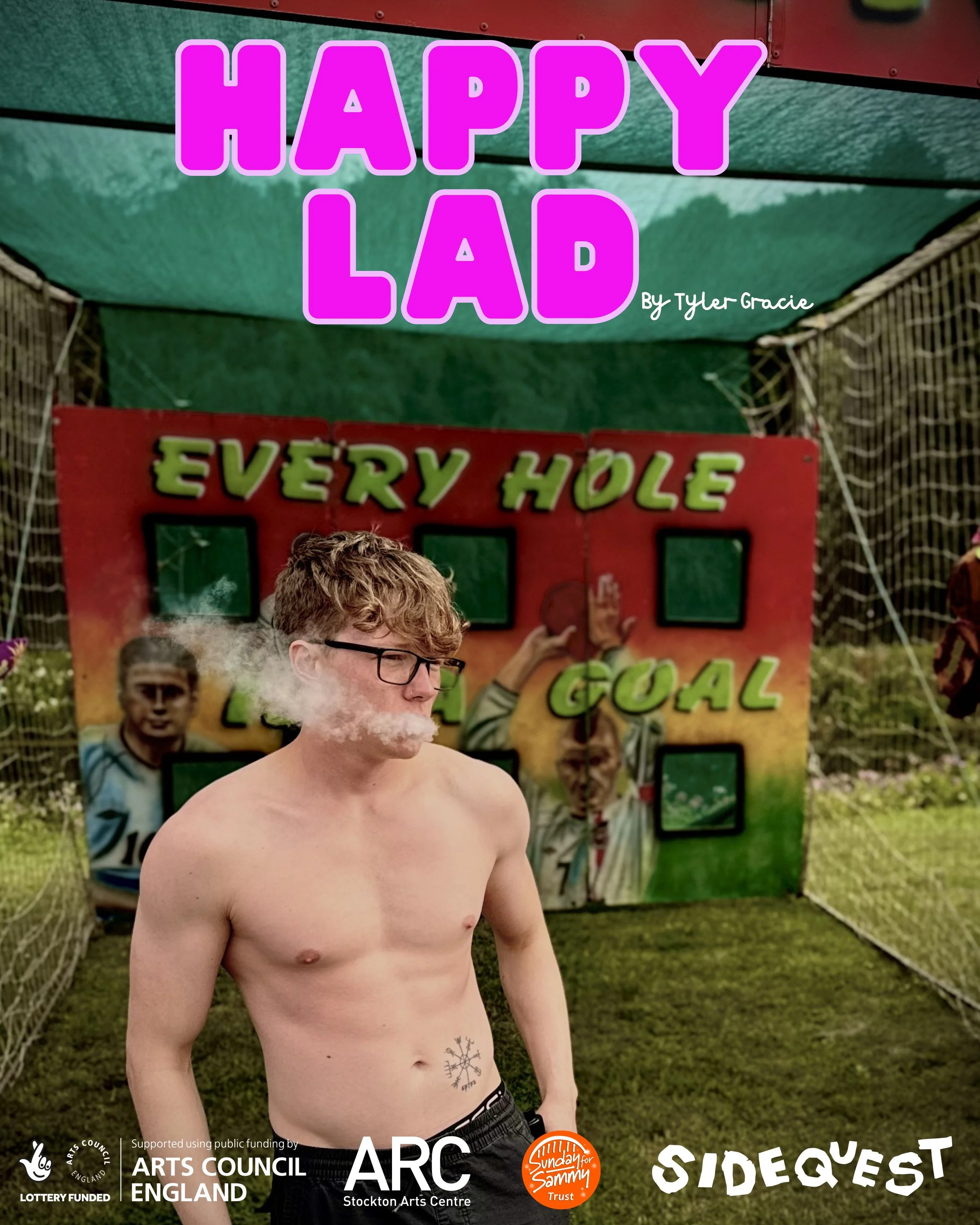 A shirtless young man with glasses and short curly hair standing outdoors in front of a colorful background with a sign that reads 'HAPPY LADS' in large pink letters, and a smaller sign below with partially visible text 'EVERY HOLE.' The scene appears to be part of an event or festival sponsored by Arts Council England, Stockton Arts Centre, and Sunday for Sammy Trust.