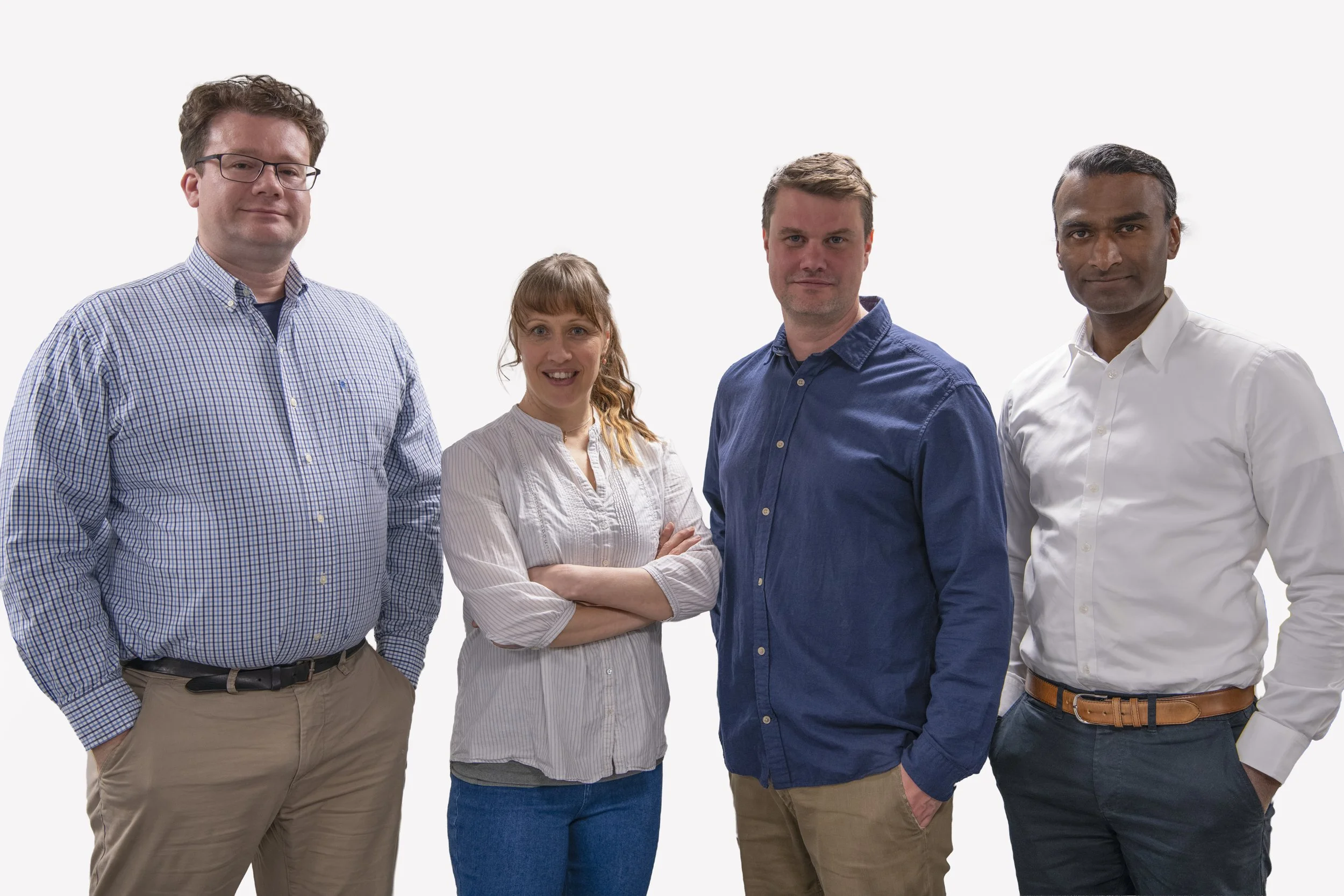 Group of four owners of the company, diverse professionals standing together against a white background, looking at the camera.