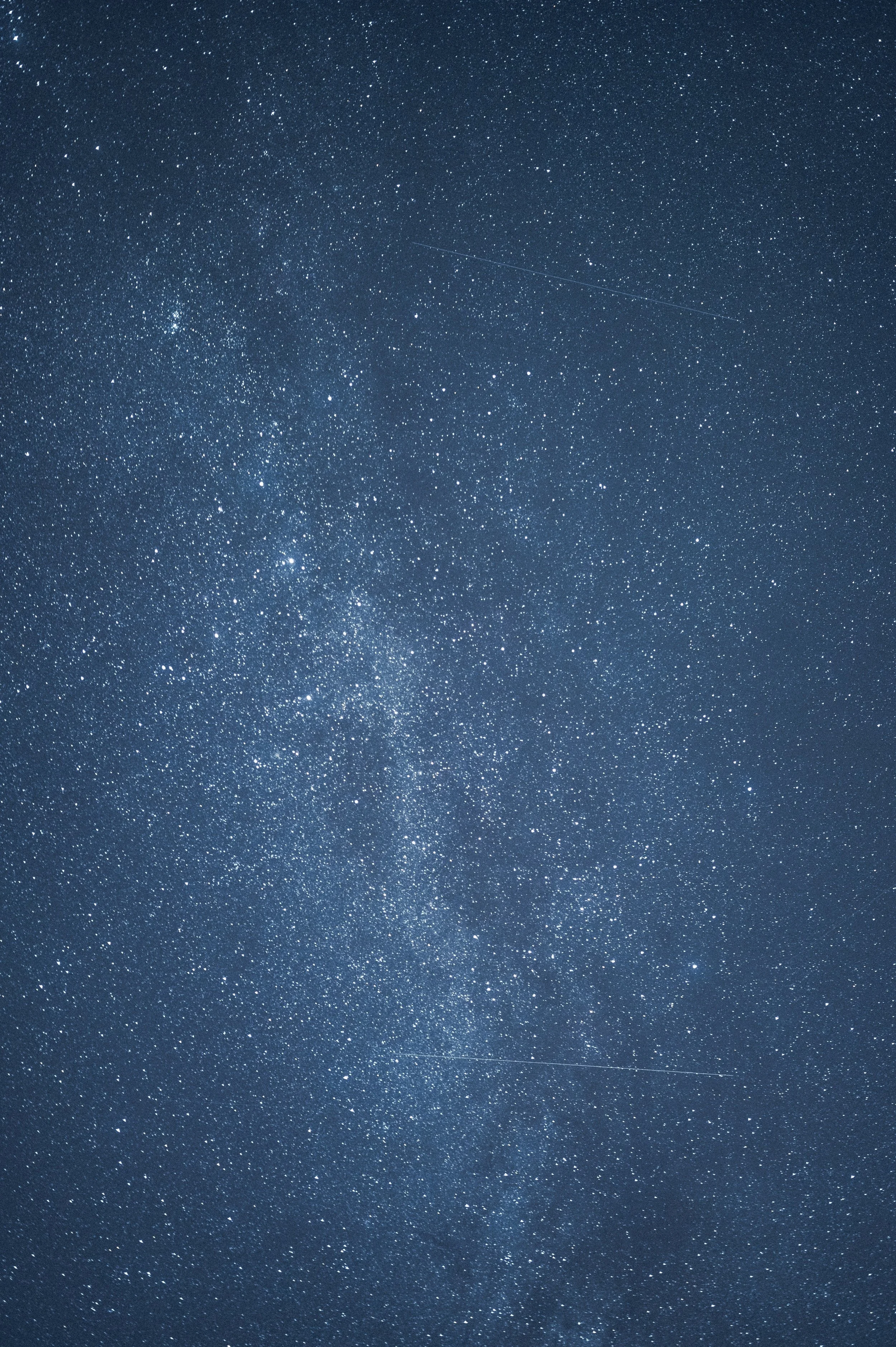 Clear night sky filled with many stars and a faint shooting star.