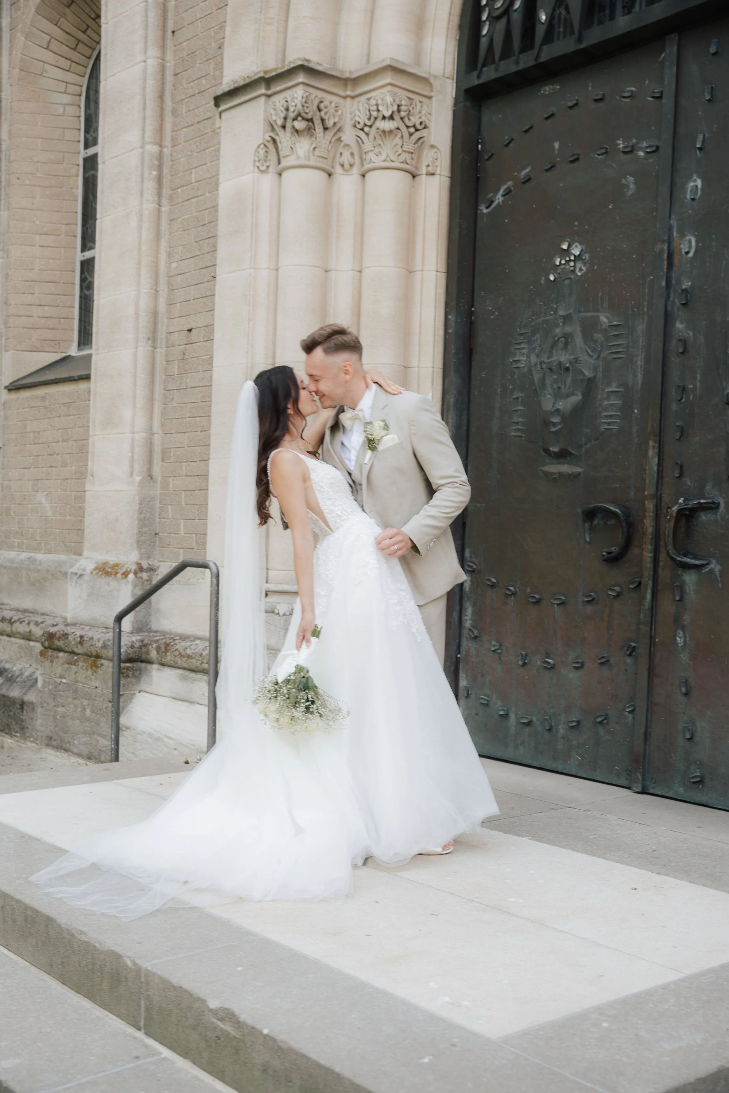 Bride and groom sharing a kiss outside a church, captured by Europe wedding photographer Änna Photography.