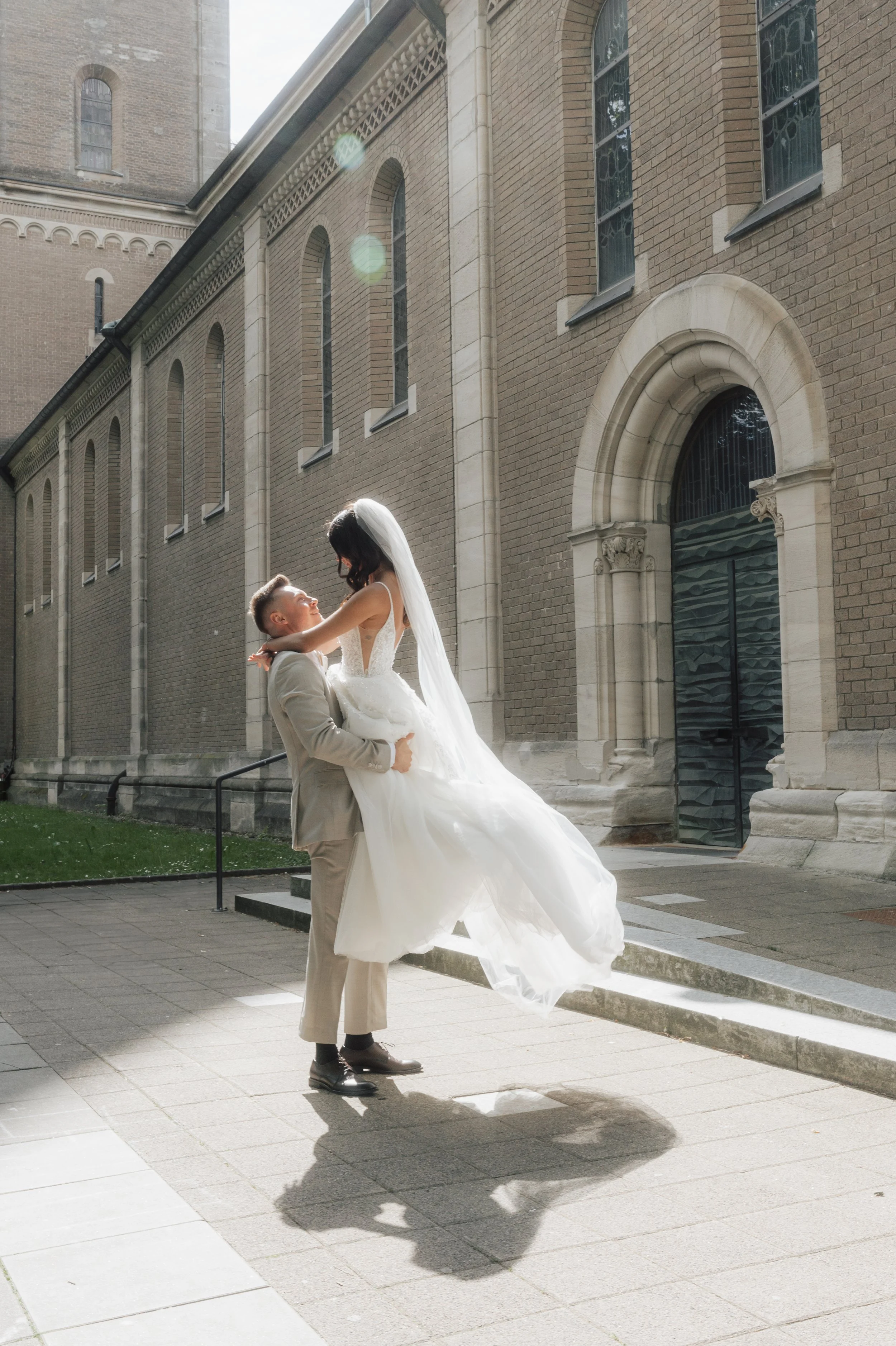 Bride and groom sharing a joyful moment outside a historic church, captured by Europe wedding photographer Änna Photography.