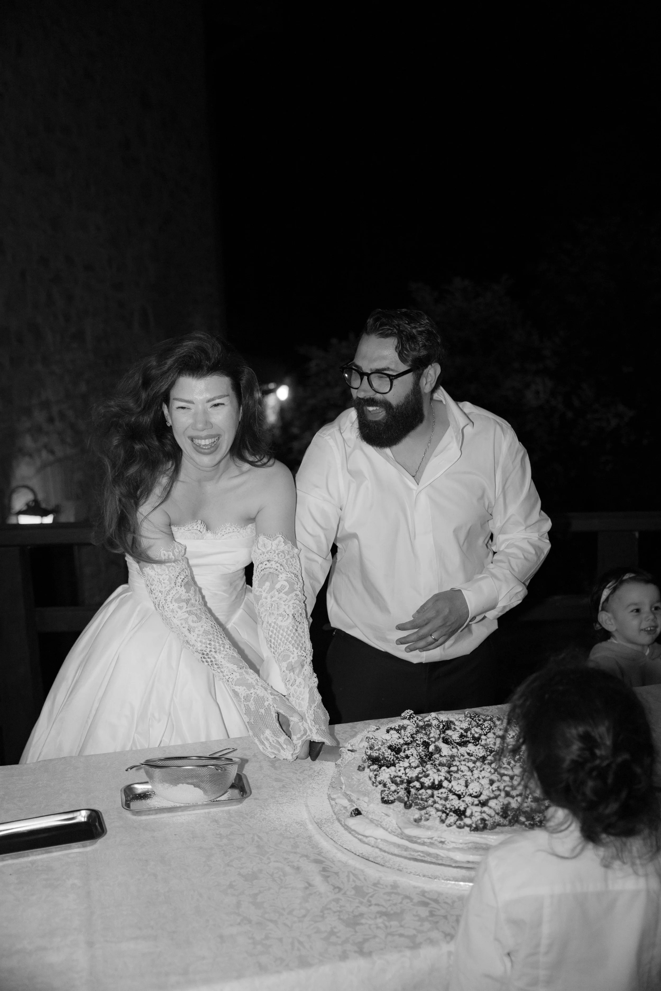 Bride and groom cutting their wedding cake during an elegant evening reception captured by Europe wedding photographer Änna Photography.