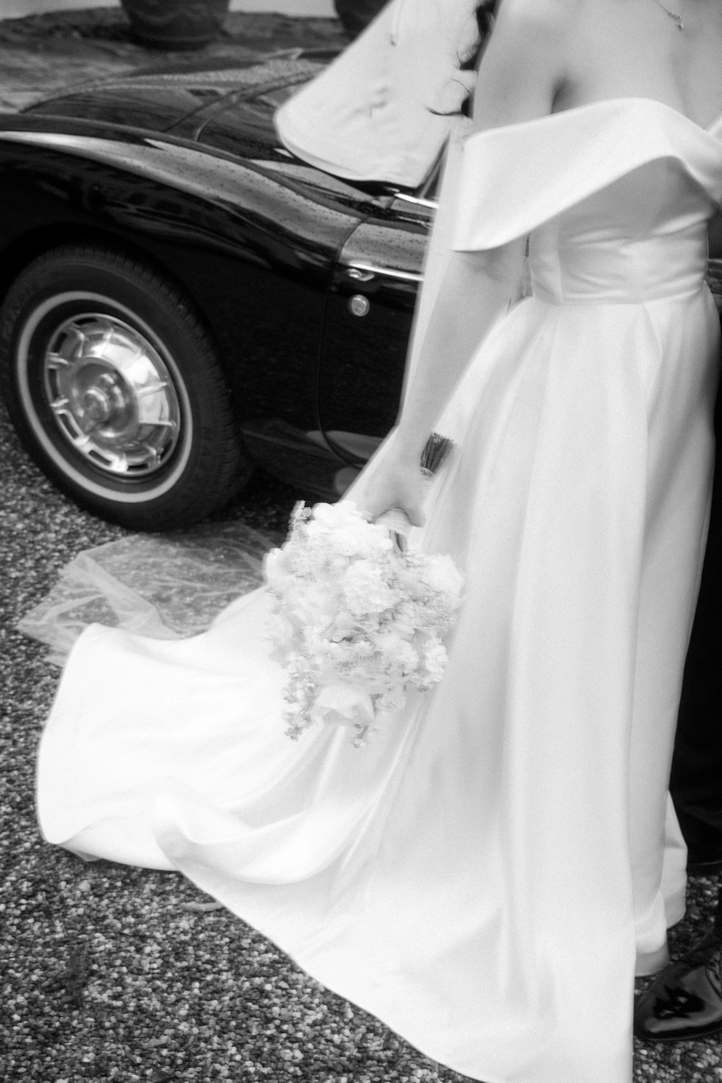 Elegant bridal bouquet and wedding dress beside a vintage car, captured by Europe wedding photographer Änna Photography.