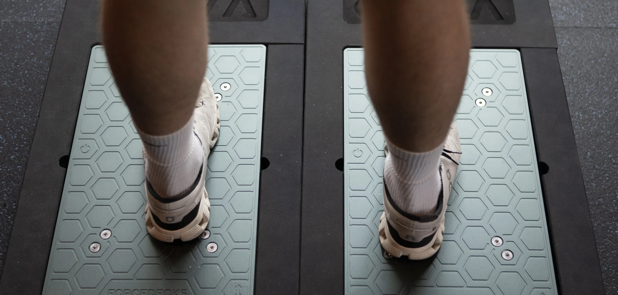 Active adult standing on VALD ForceDecks dual force plate system during a movement analysis at A.I.R. Performance