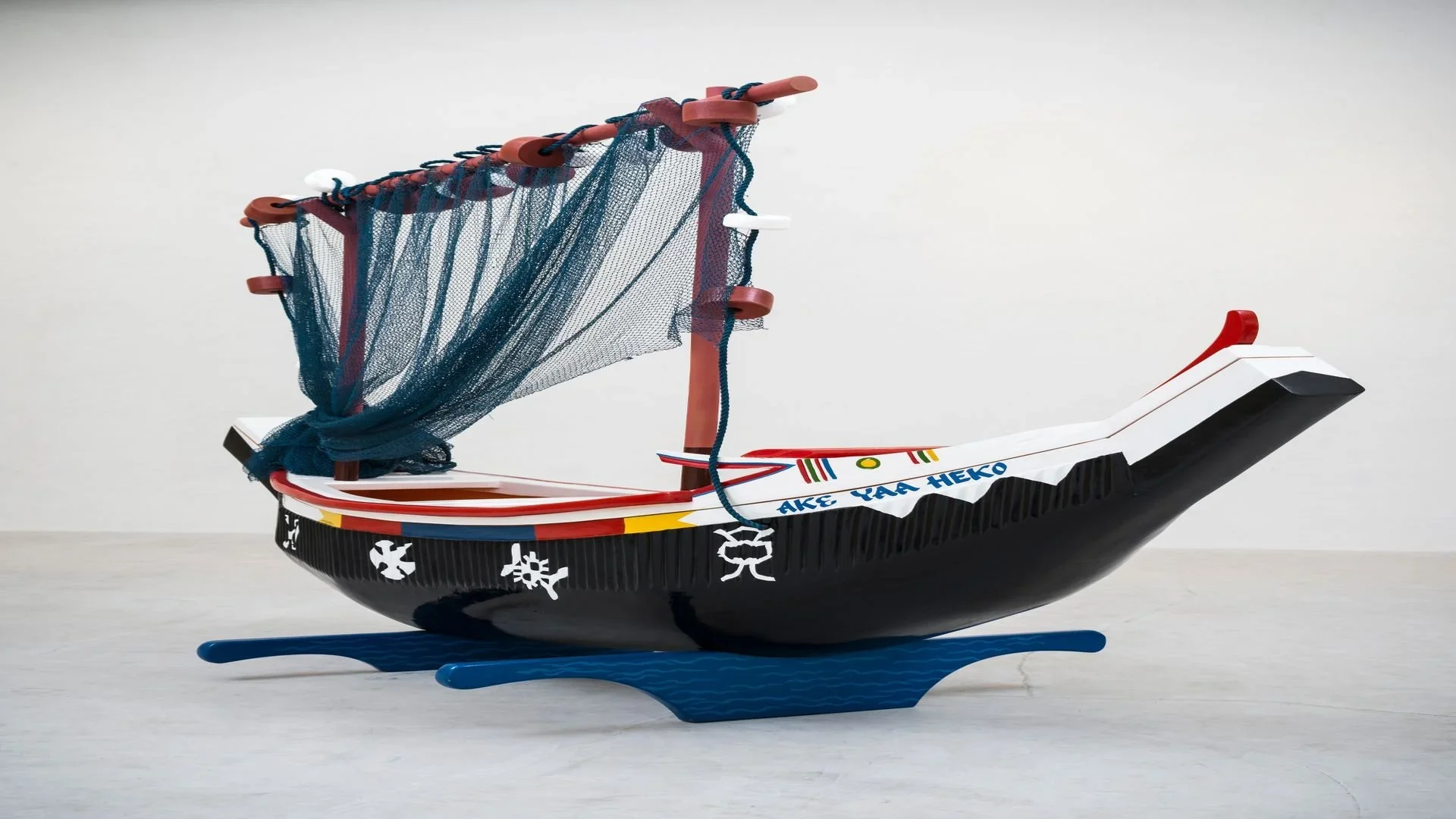 An image of a Ghana fantasy coffin which is shaped liked a narrow boat with one draping sail