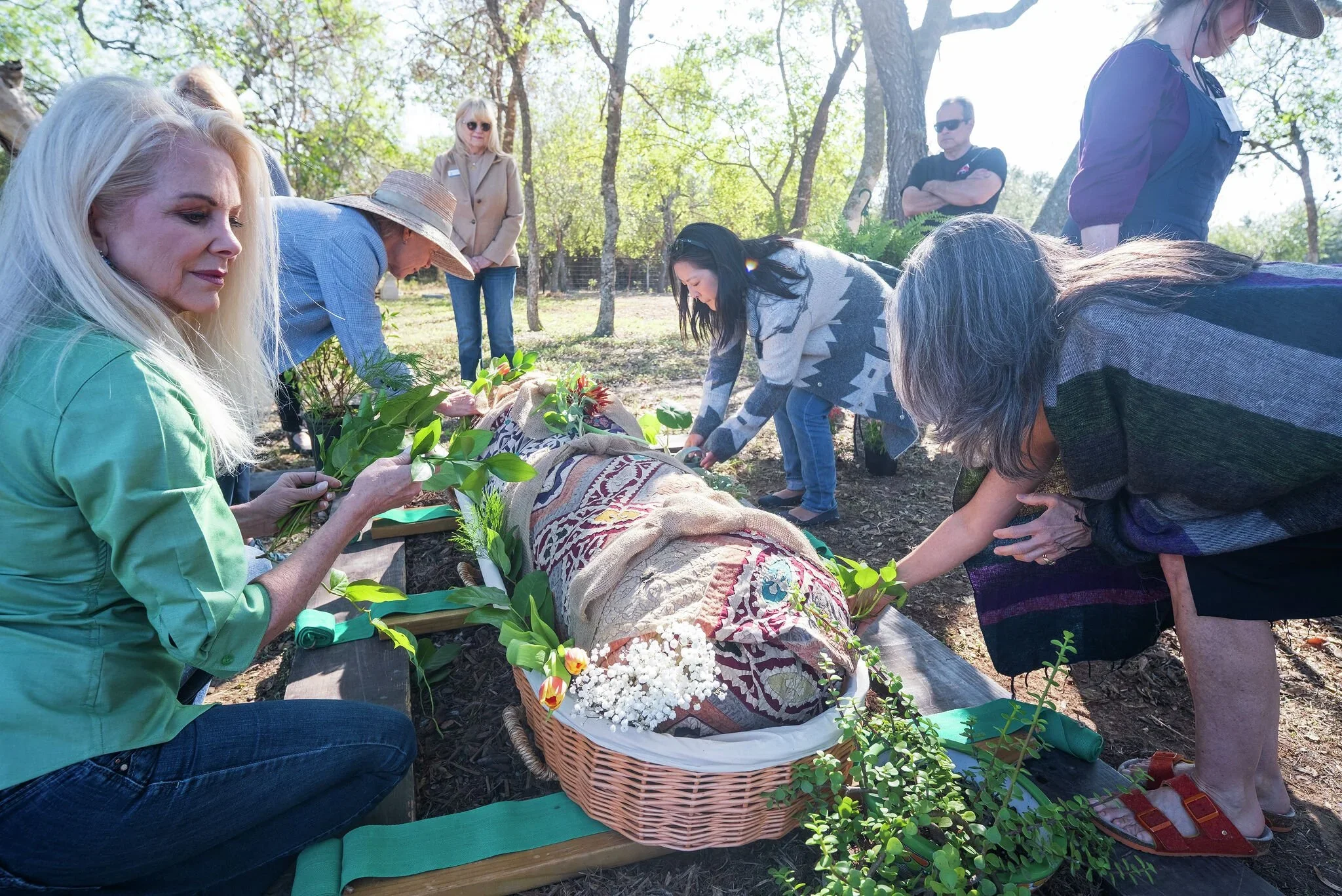 A image of a group of mourners preparing a body for a natural burial