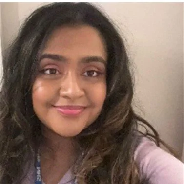 Dr Tharushi Denipitiya, Wellcare Health, Beverley, with long wavy hair smiling at the camera.