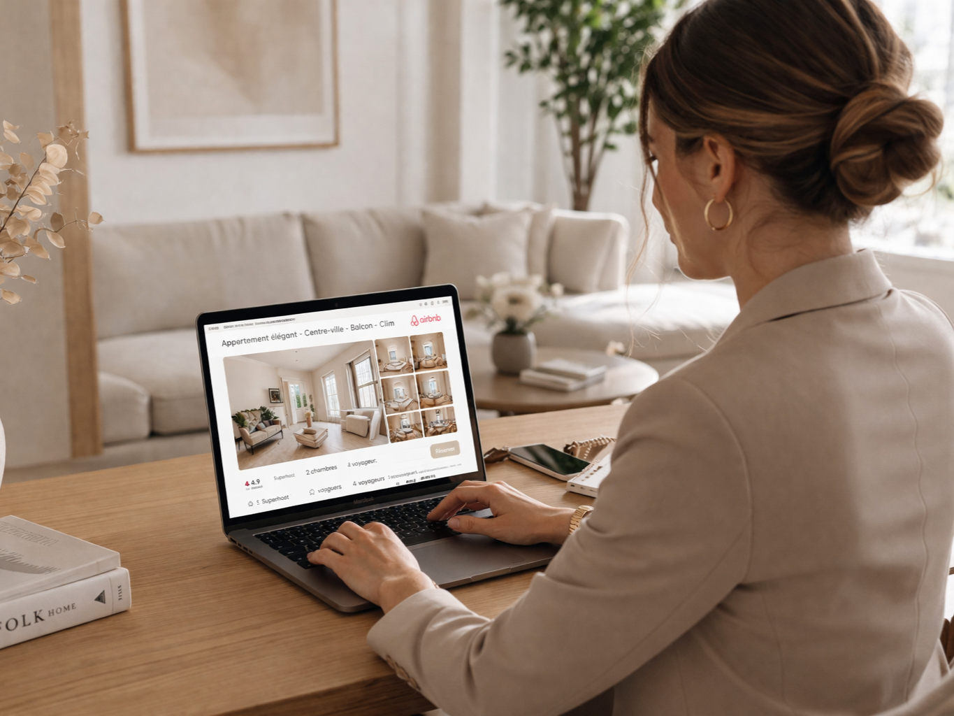 Femme regardant une annonce de location d'un appartement élégant sur un ordinateur portable dans un salon lumineux et décoré avec goût