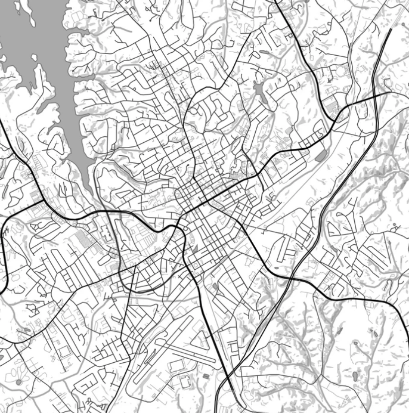 A black-and-white map showing the street layout and geographical features of a city with a waterfront area on the left side.