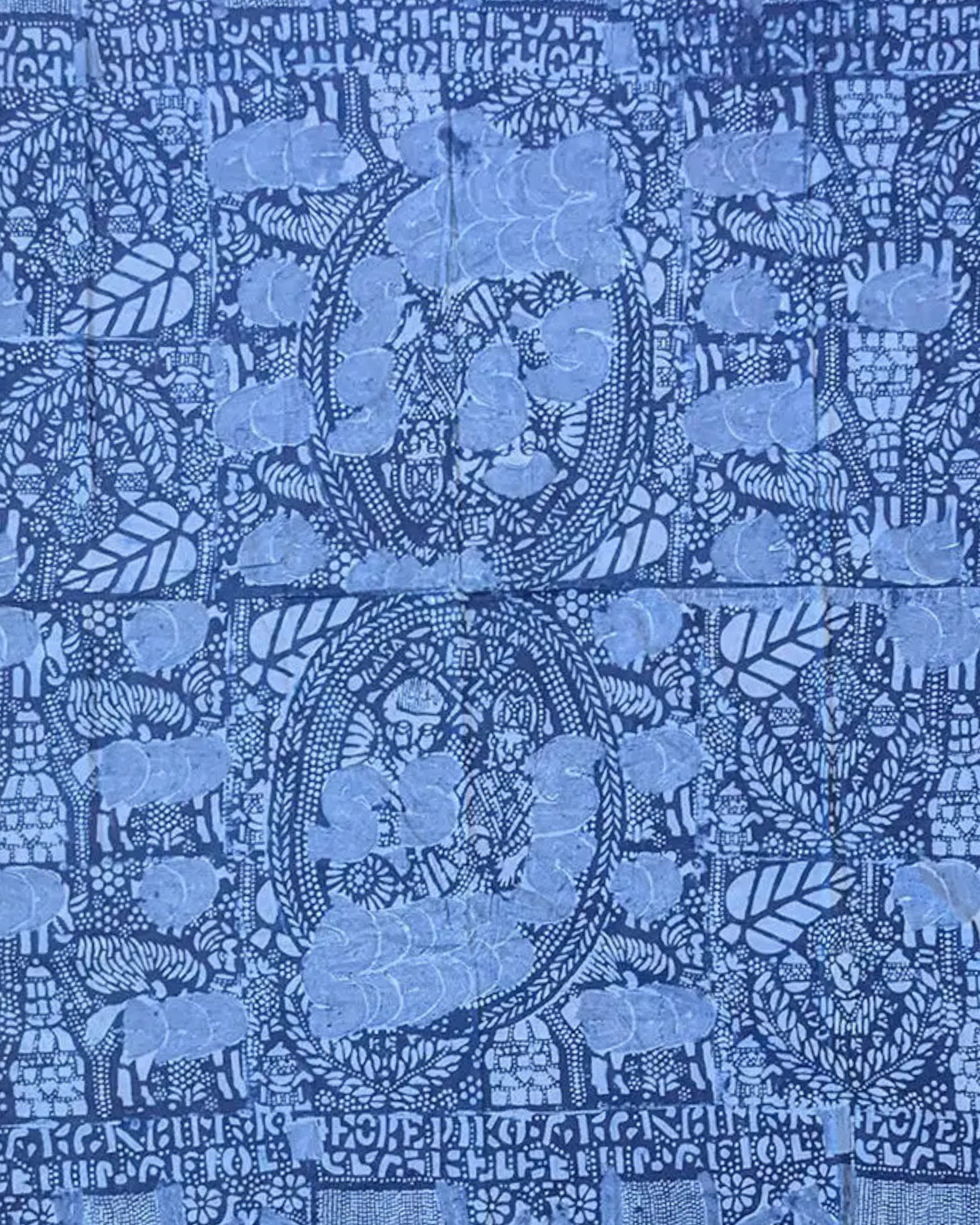 Close-up view of an intricate Adire textile featuring floral patterns, geometric shapes, and alphabet letters.