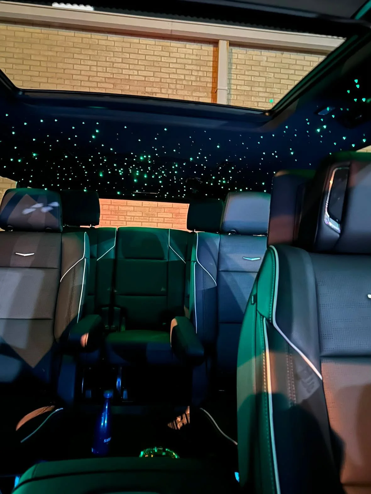 Interior of a Black Truck with a starry sky ceiling and black leather seats.