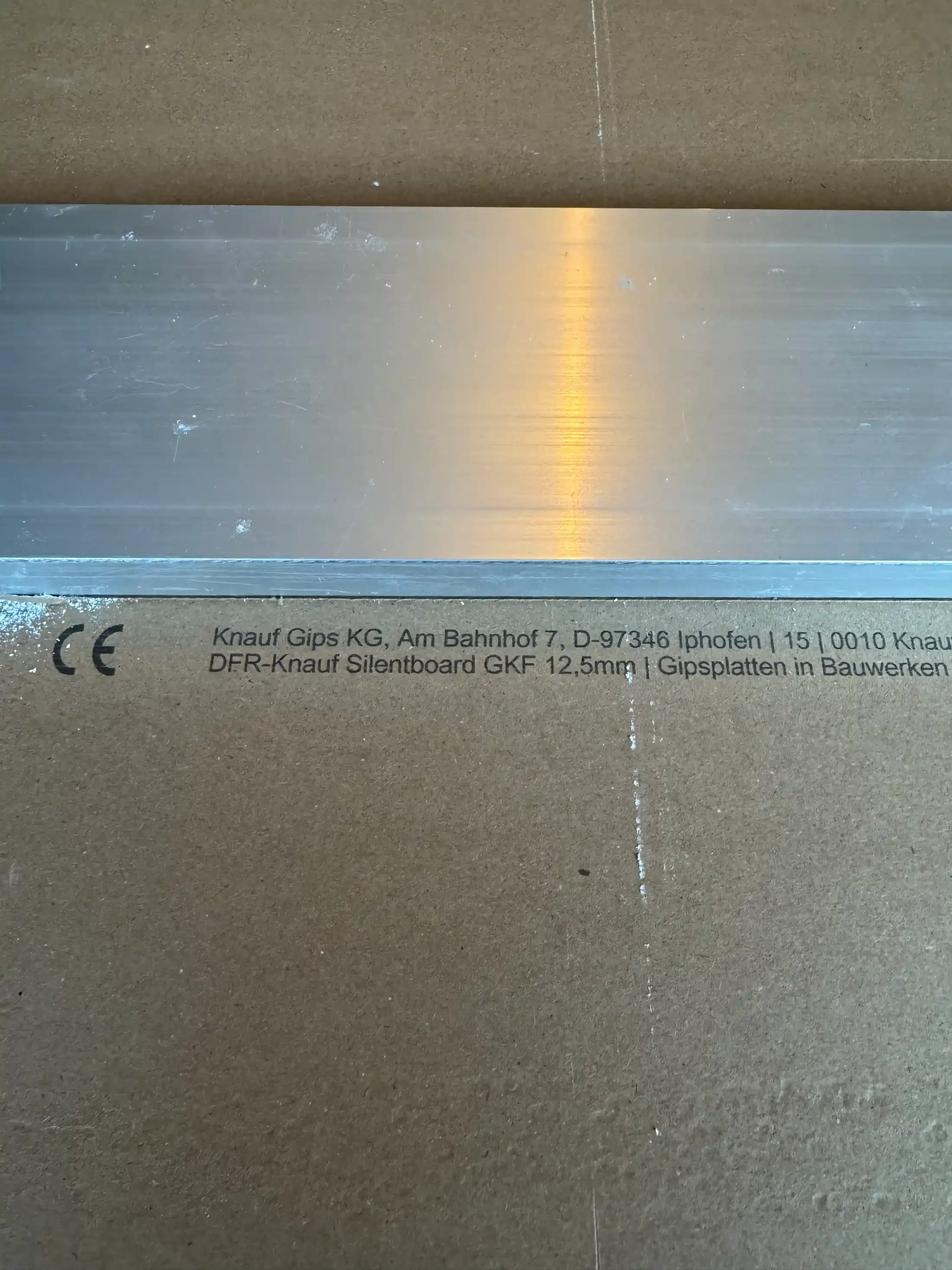 Разчертаване на плоскост Knauf Silentboard преди рязане за шумоизолация на стена.