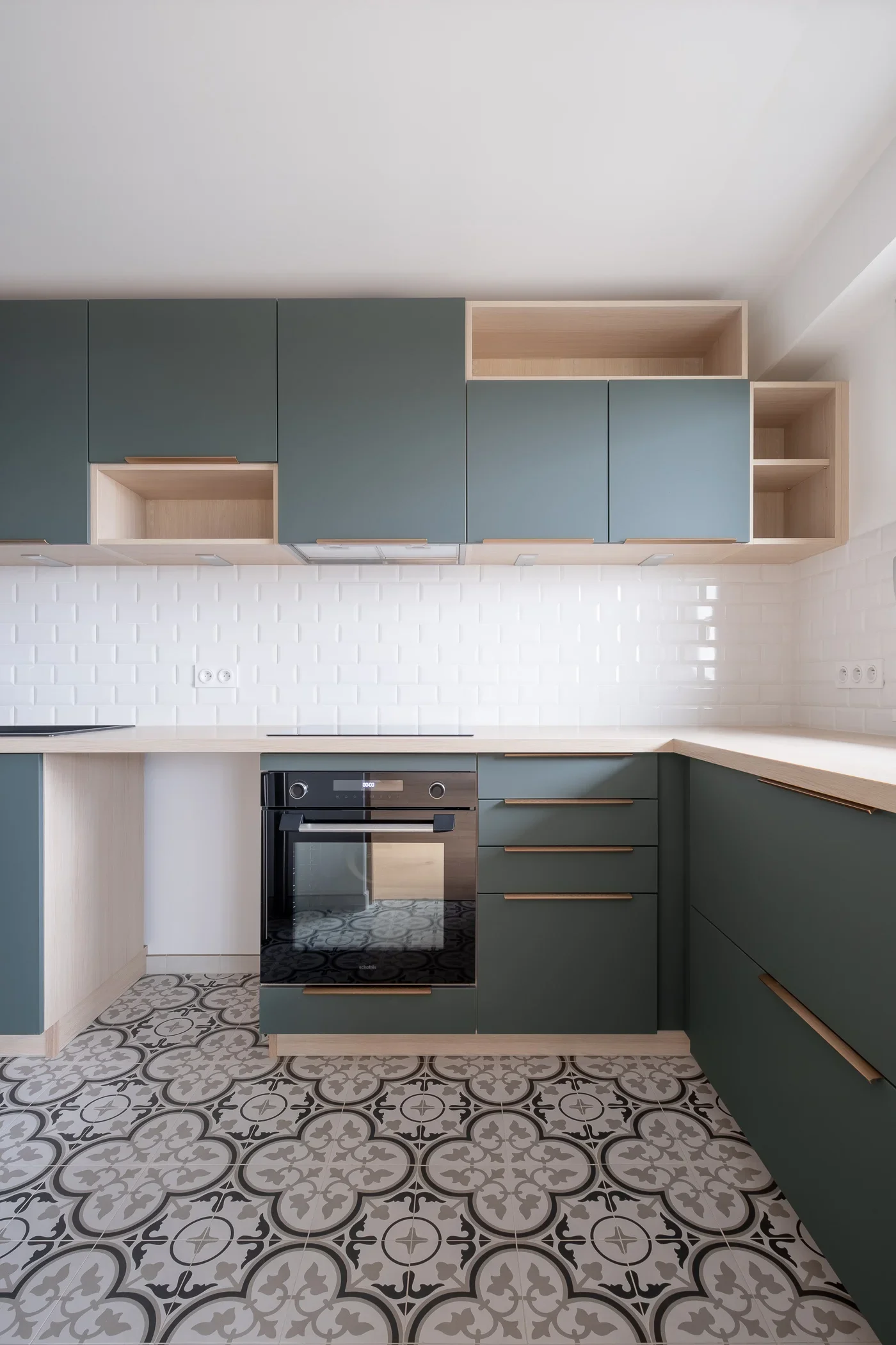 Монтирана кухня с вградена фурна, свързана мивка и гръб от бели плочки тип метро.