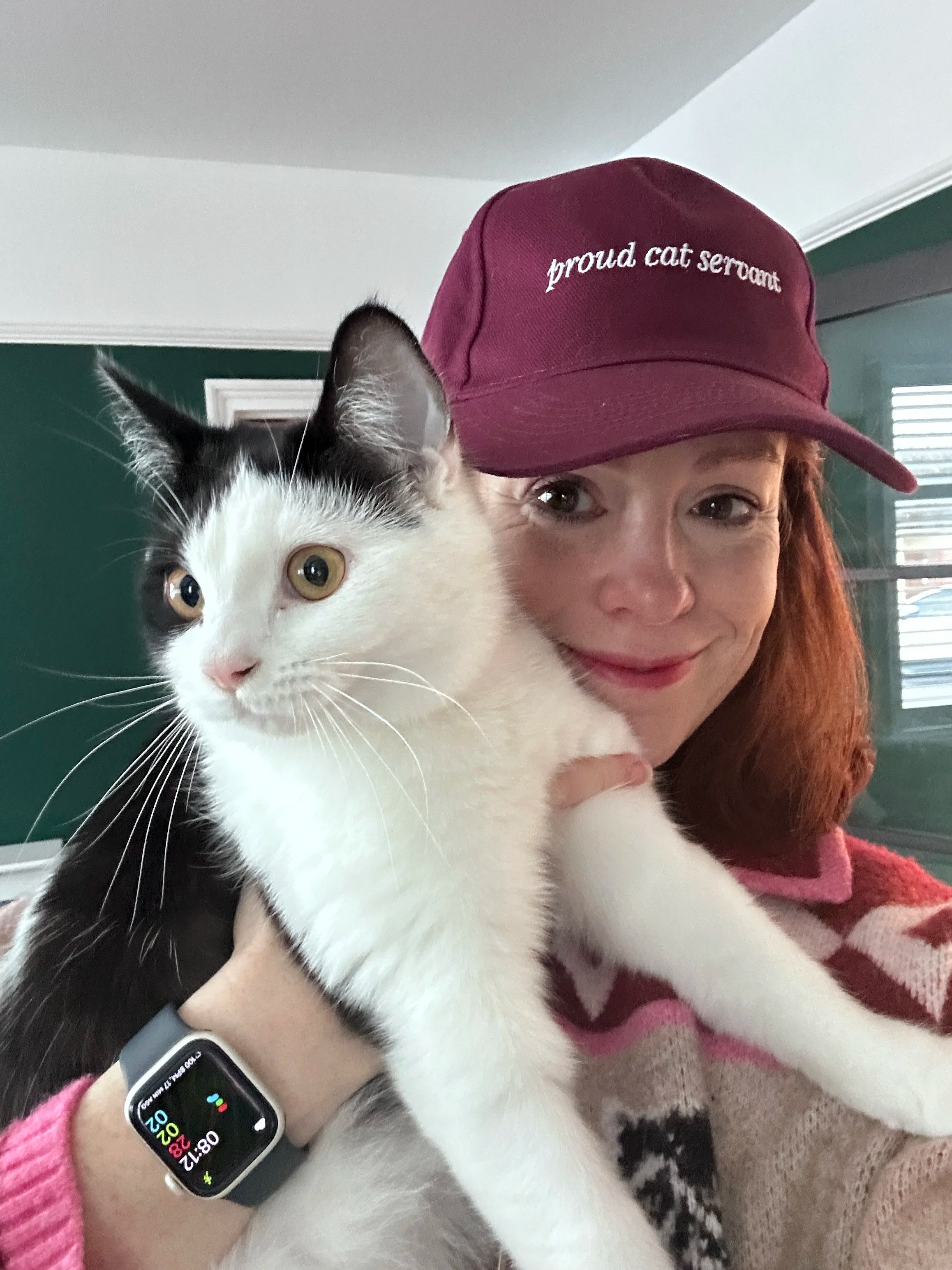 Emily holding a black and white cat – professional cat sitting services