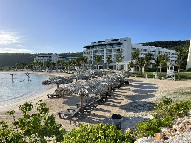 Oceanfront resort with lounge chairs and clear blue water, ideal for a laid-back beach experience