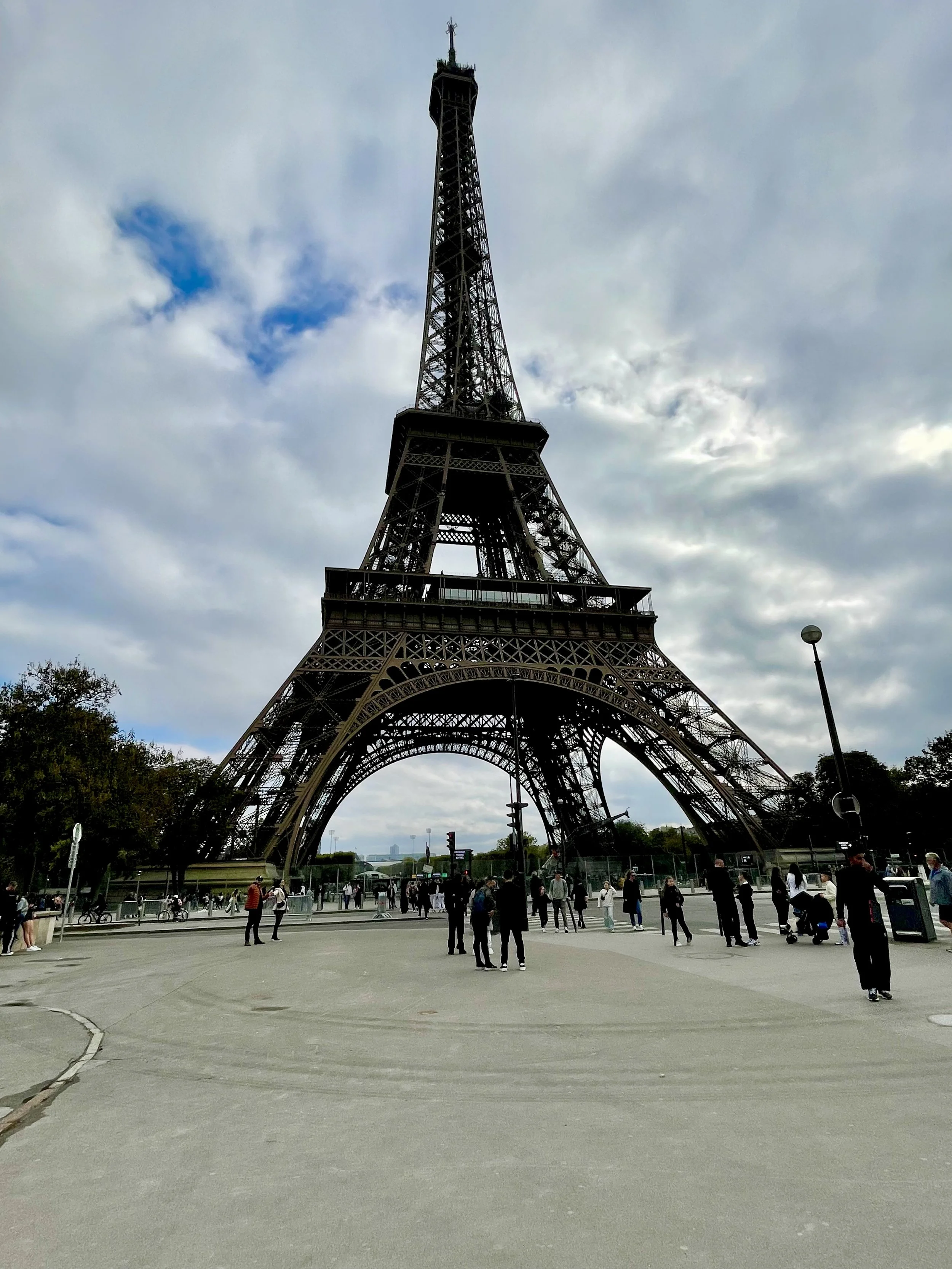 Eiffel Tower in Paris viewed from below with people walking nearby