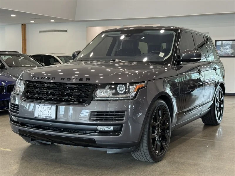 Gray Land Rover SUV parked inside a car dealership showroom.