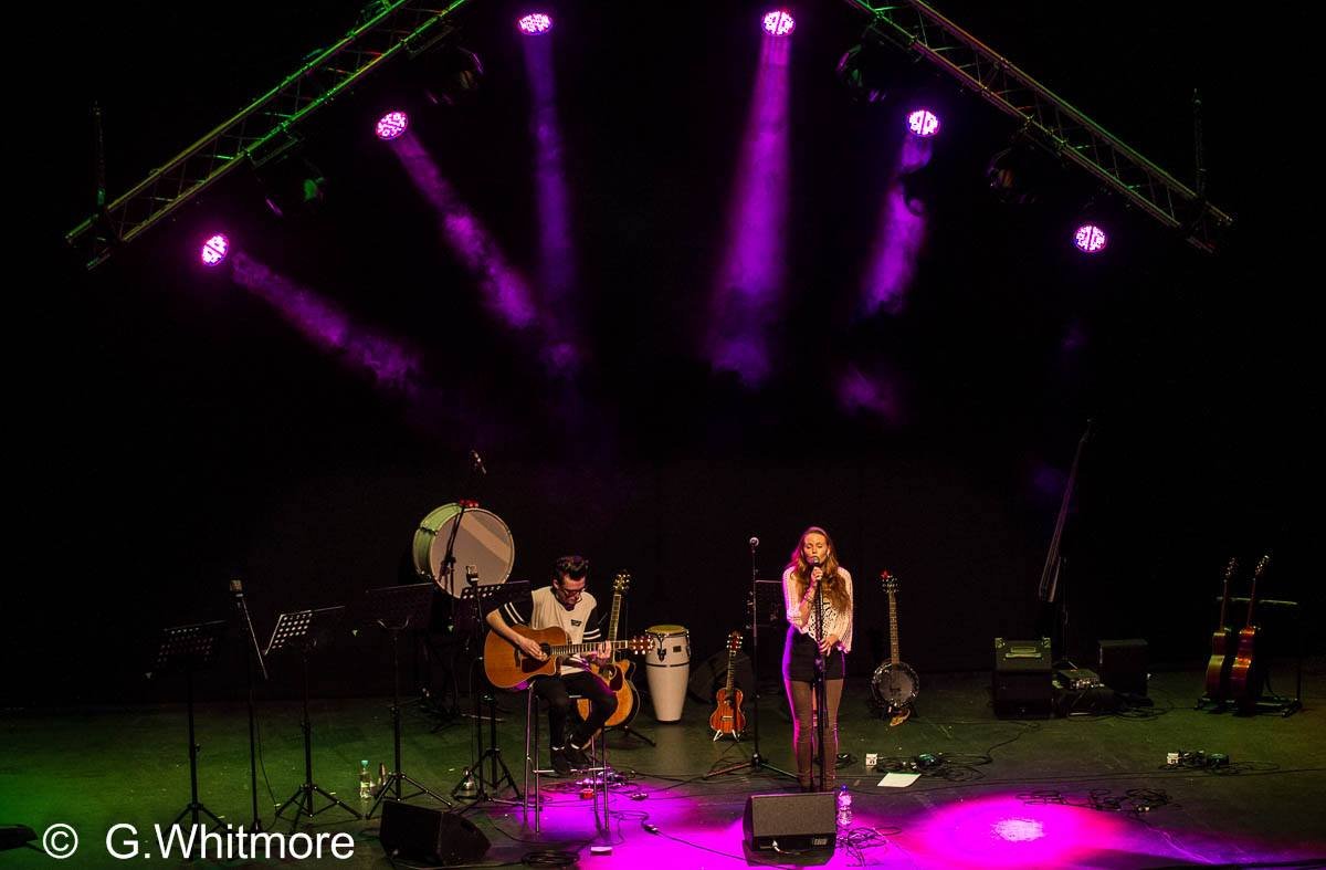 Kay Acoustic live acoustic duo performing on a large theatre stage under full spotlights, providing professional wedding and event entertainment.