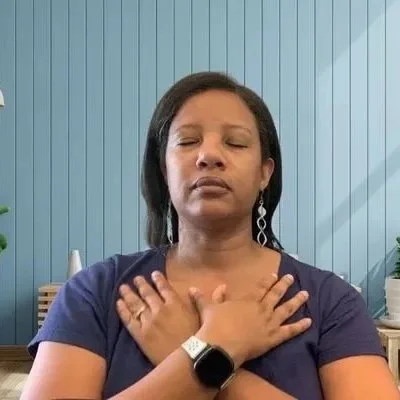 Woman with closed eyes, crossing arms over her chest in a meditative pose