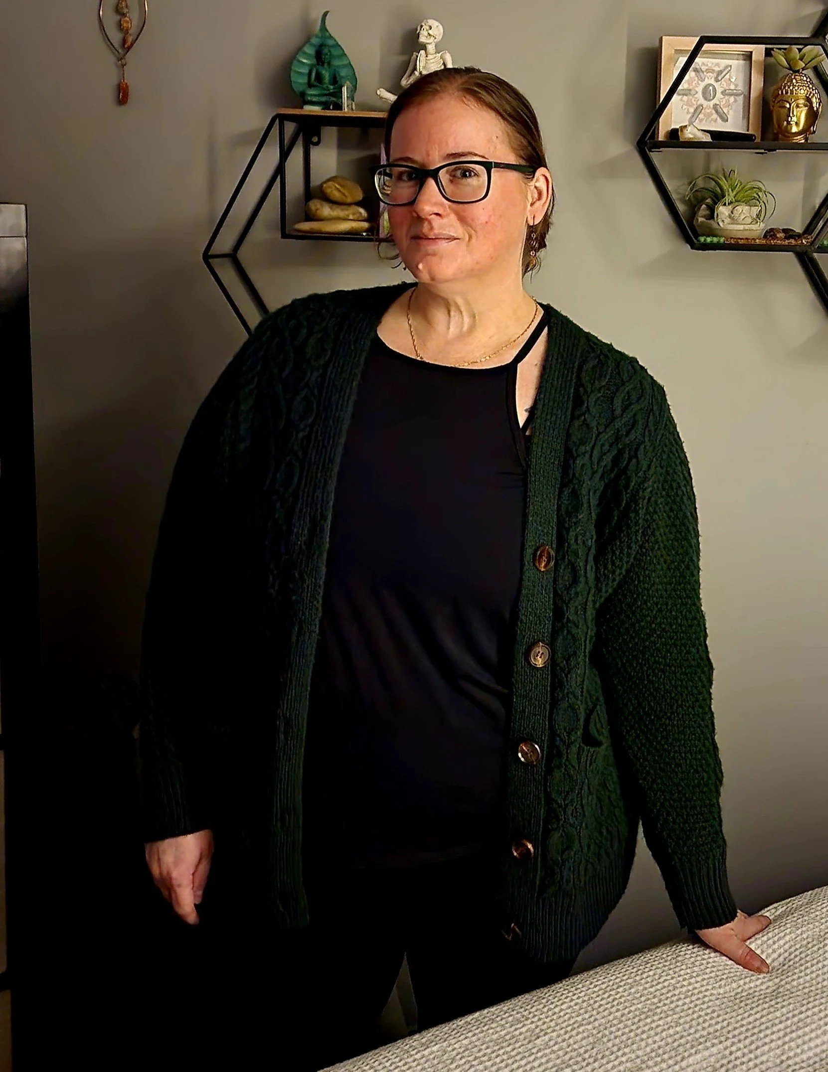 Erika standing beside a massage table in her treatment room.