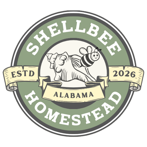 Logo with green and beige colors, featuring a hand holding a bee on a flower, with text "Shellbee Homestead Alabama ESTD 2026".