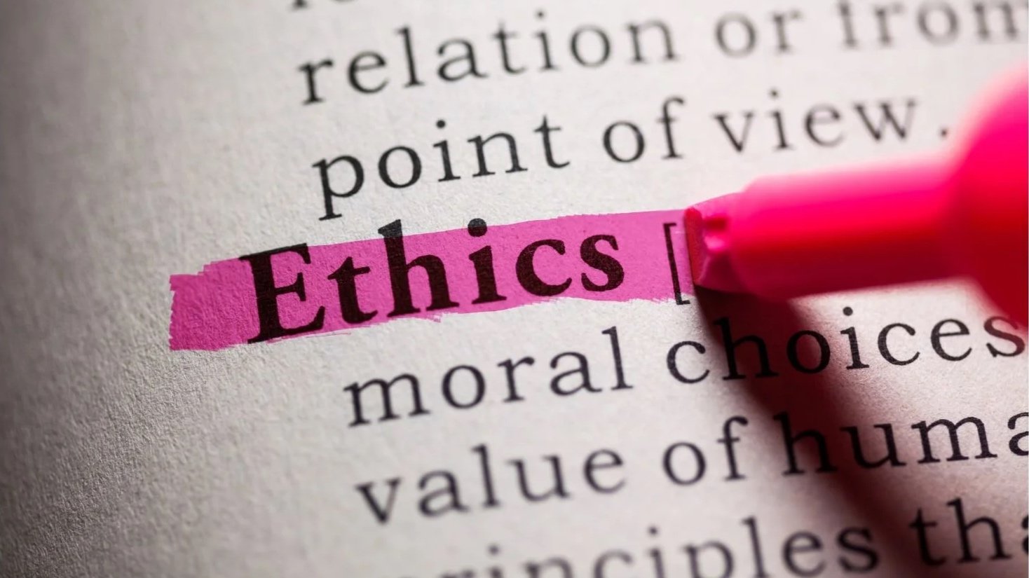 Close-up of a printed page with the word 'Ethics' highlighted in pink and a pink marker pen pointing at it.