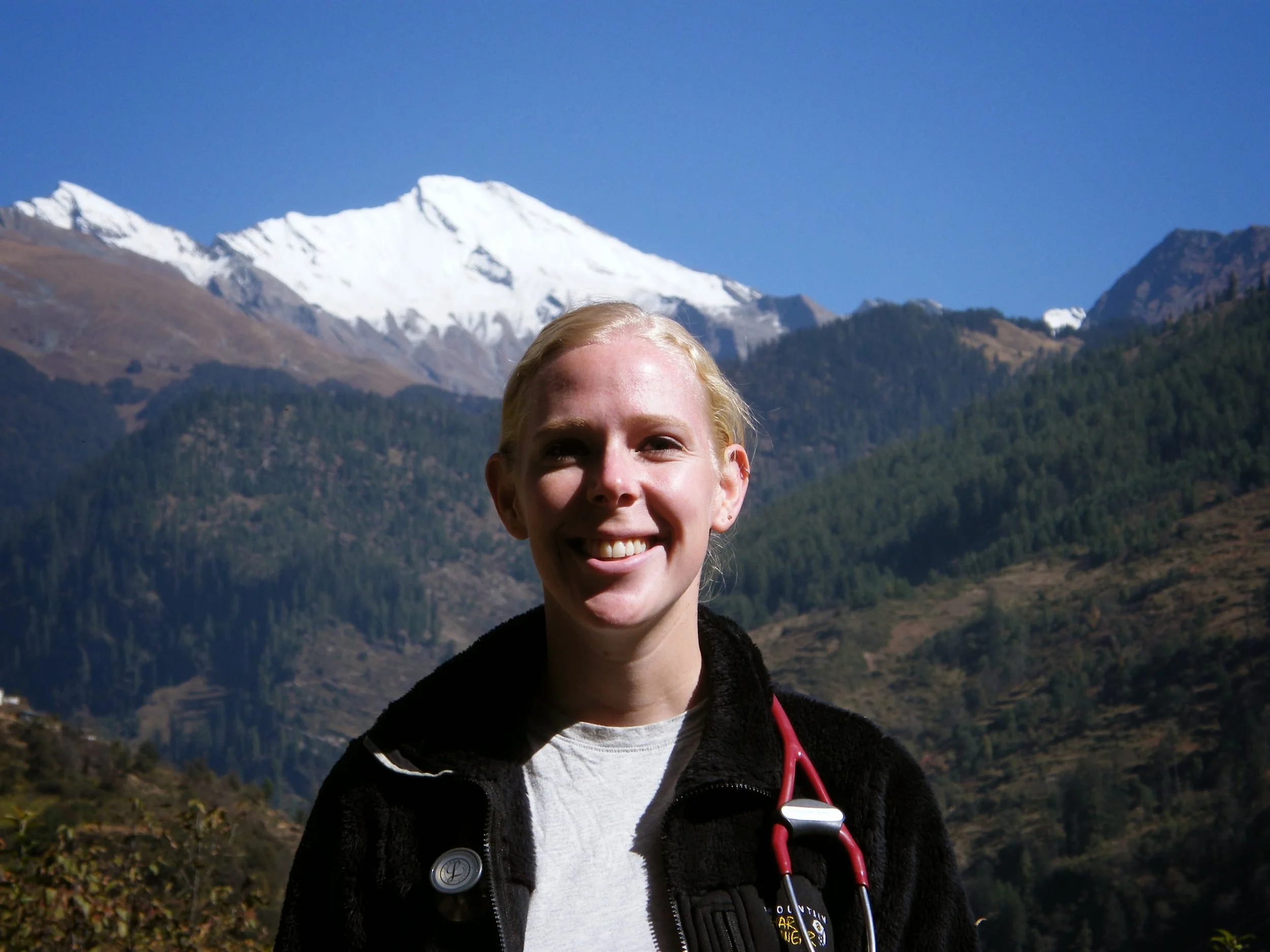 The founder of Elevation Provider Wellness physician burnout coaching with stethoscope and mountain in the background.