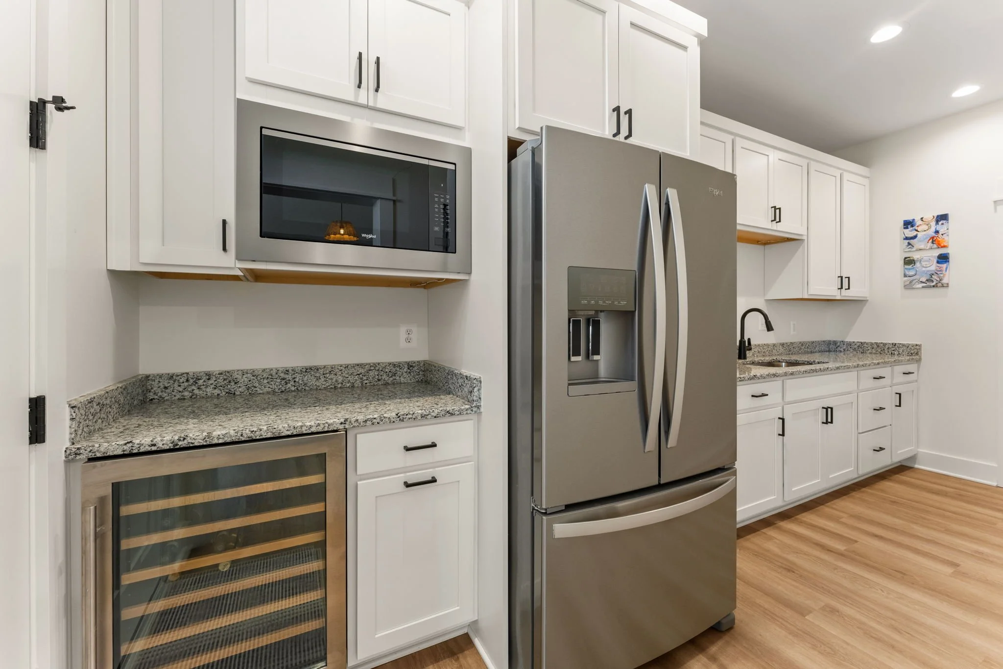 Expansive butler's pantry with stainless steel microwave, second full-sized refrigerator, and wine cooler fridge.